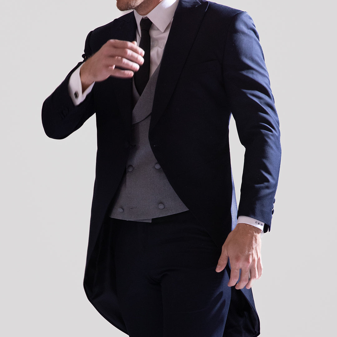 Ceremonial, impecable, inolvidable. Este conjunto de levita azul marino con chaleco doble botonadura en gris claro es una declaración de elegancia atemporal.